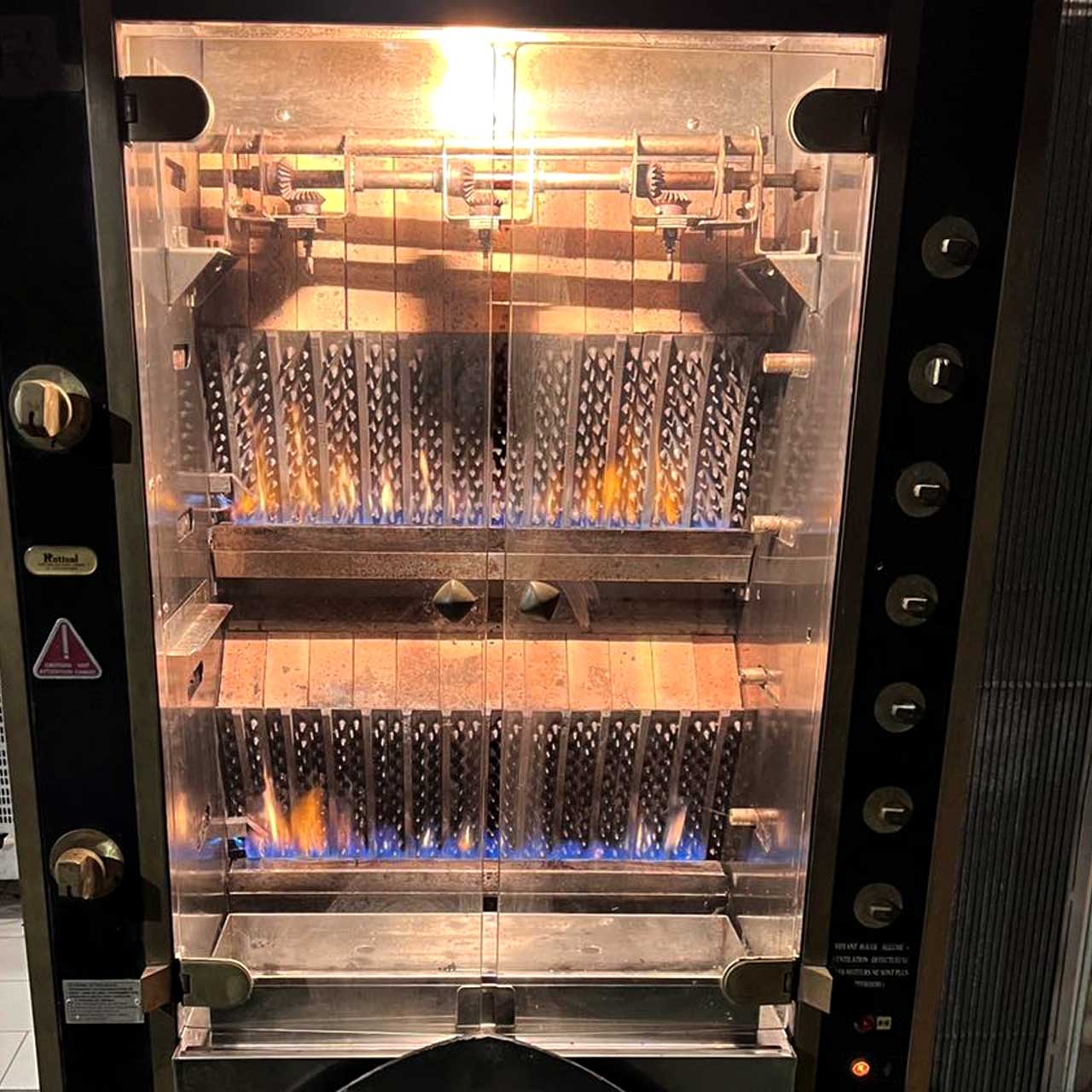 Vue de la Rôtisserie Artisanale montrant la cuisson lente du poulet.